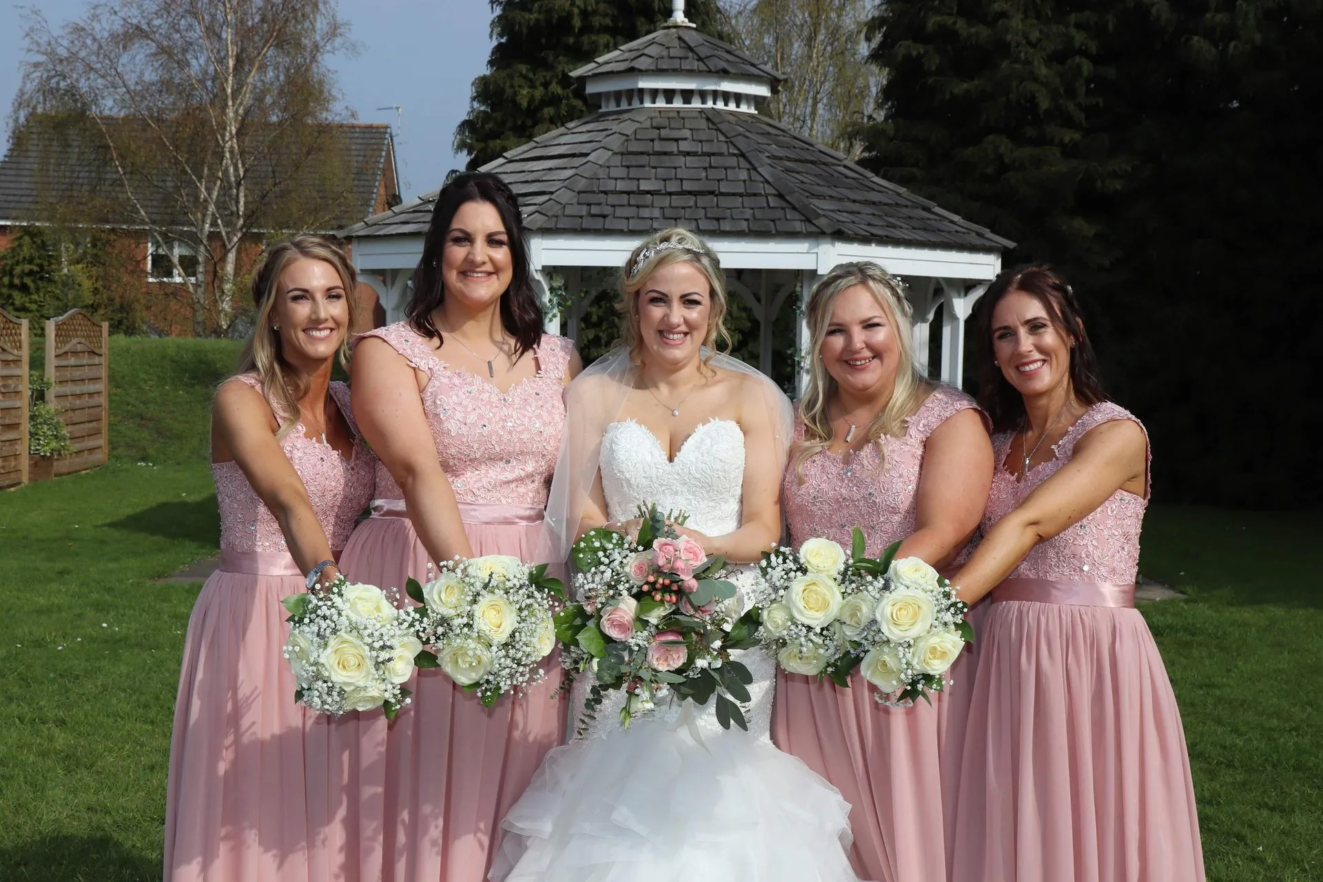 Bride with bridesmaids in pink dresses, garden wedding